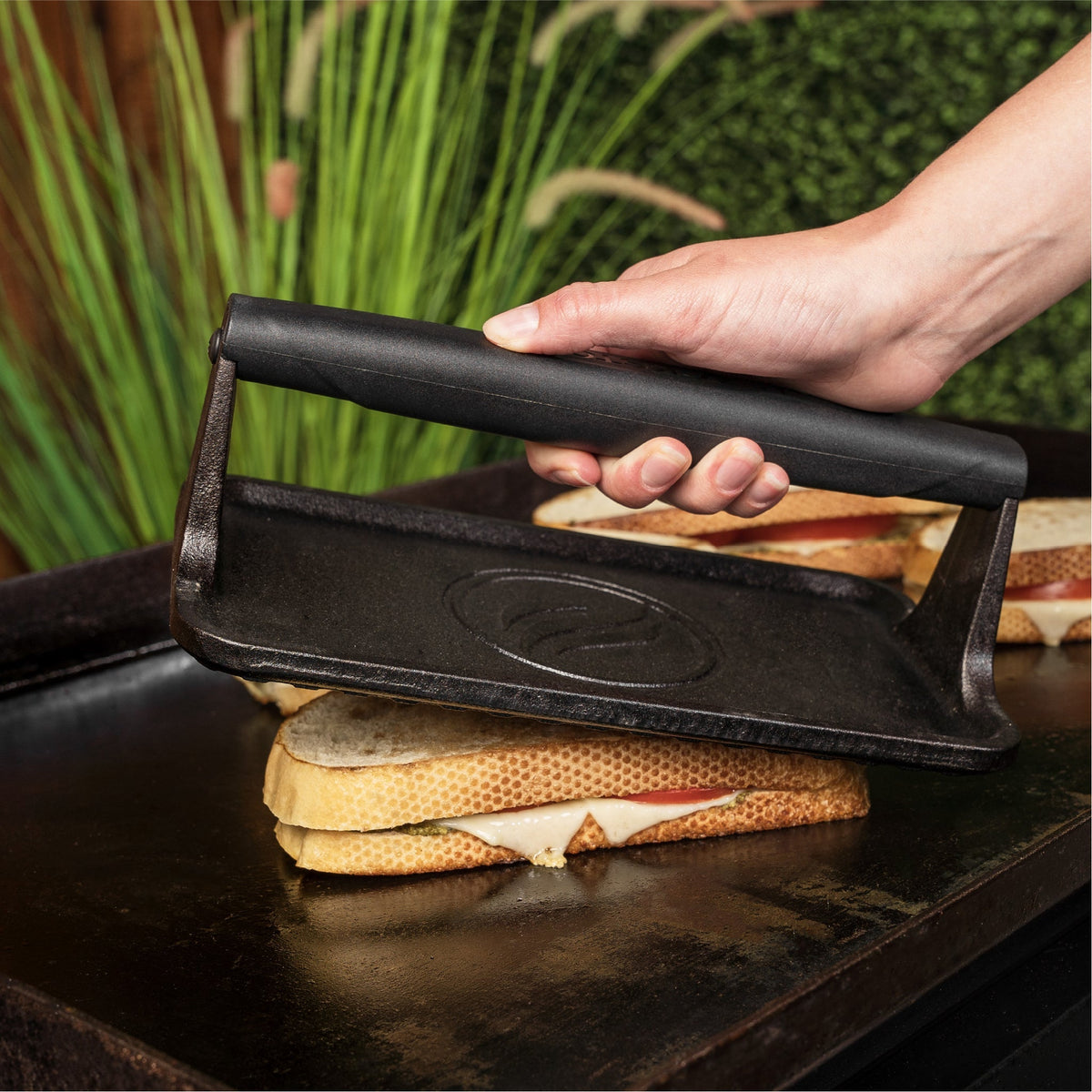 Blackstone Medium Cast Iron Griddle Press - pressing a grilled sandwich
