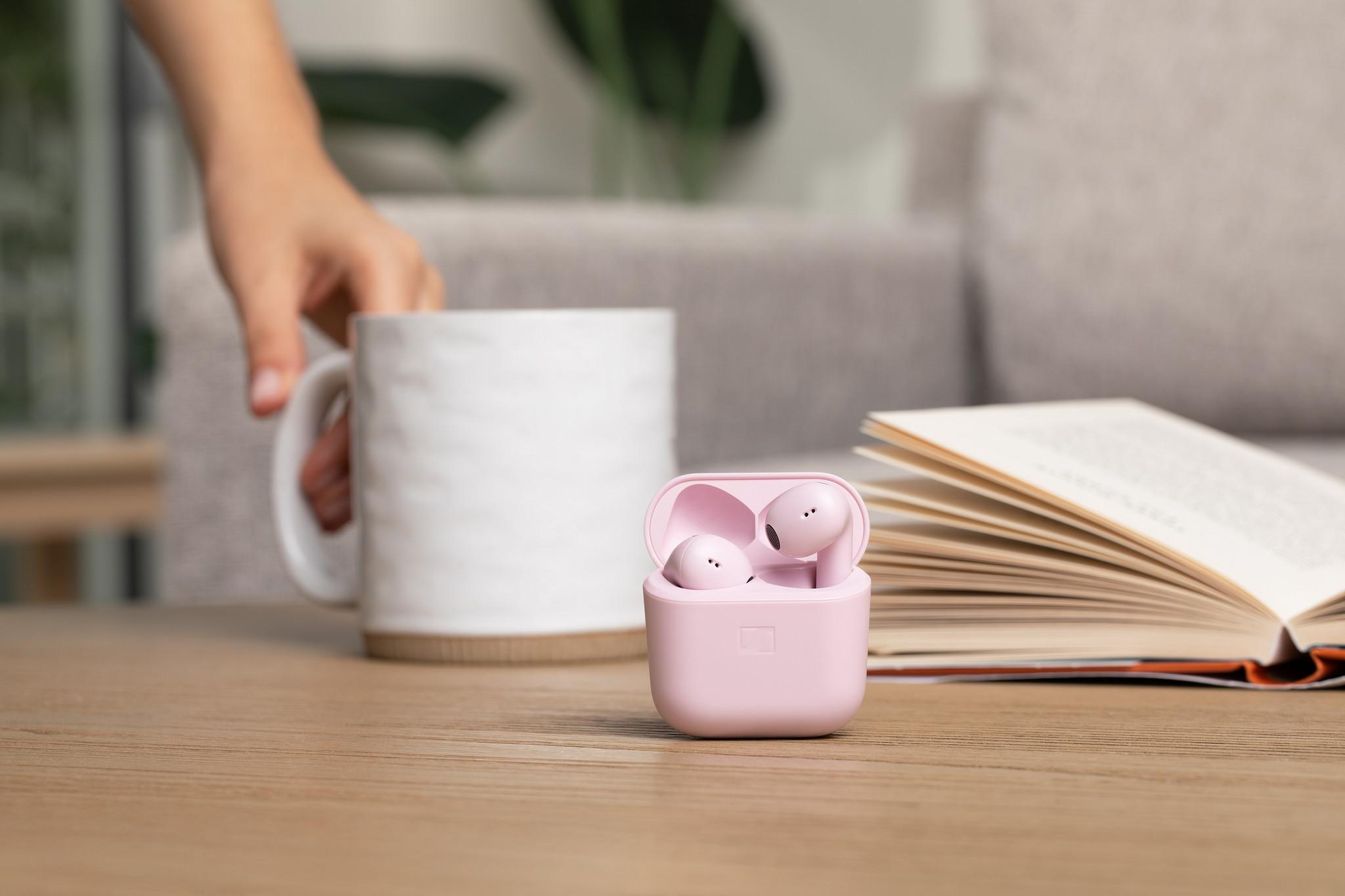 Sennheiser ACCENTUM Open True Wireless Earphones Mousse — lifestyle, case on a table with mug and book