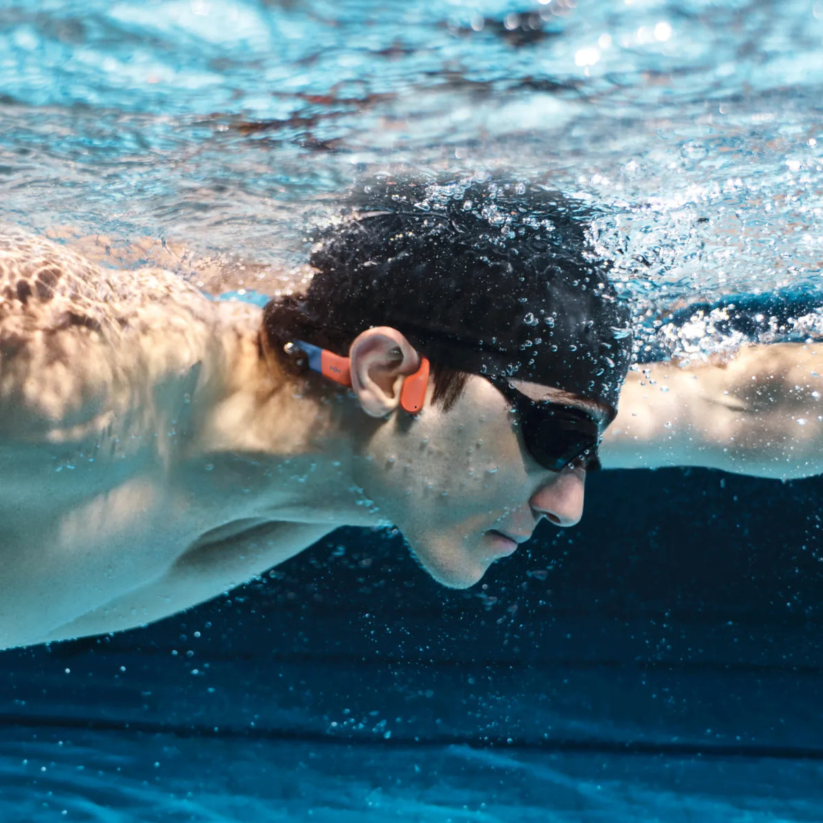 Shokz OpenSwim Pro Bone Conduction Swimming Headphones - Red - swimmer underwater