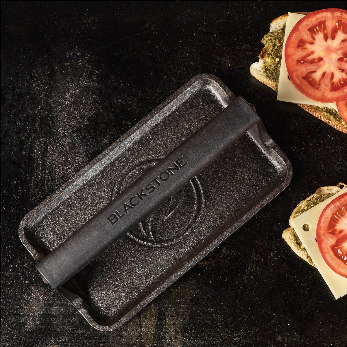 Blackstone Medium Cast Iron Griddle Press - press and sandwiches close-up