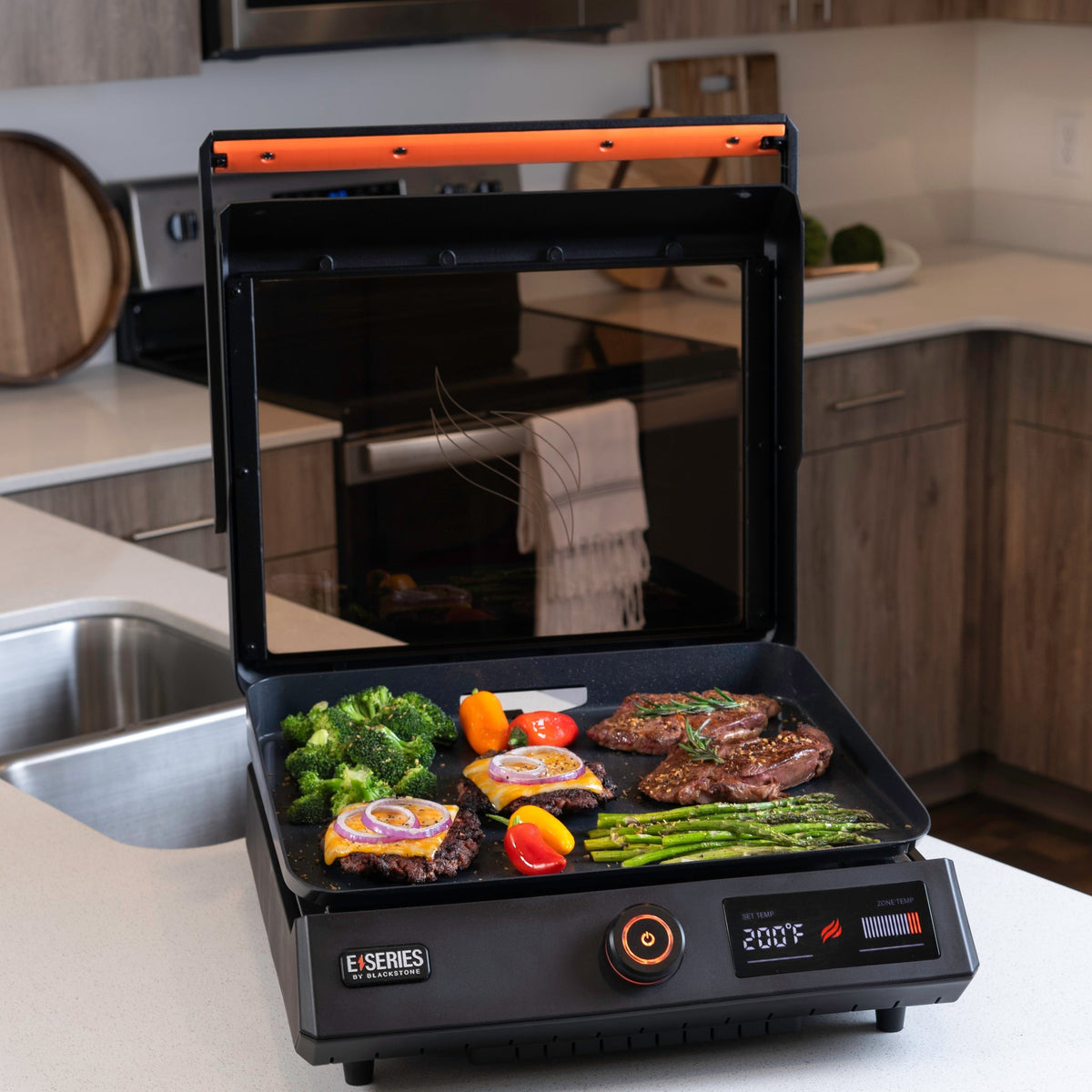 Blackstone E-Series 17" Electric Tabletop Griddle with Hood - Black - on the kitchen counter