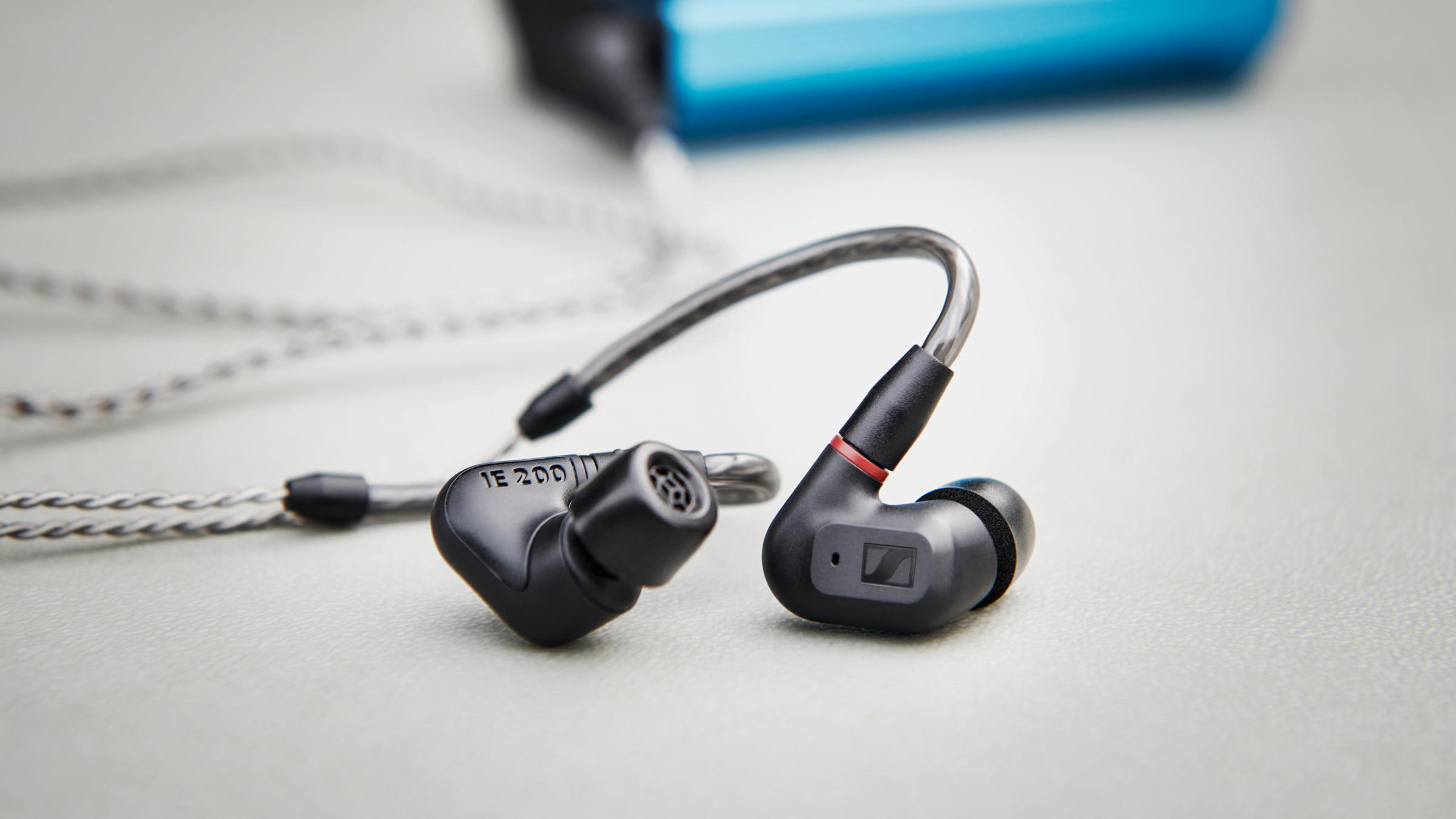 Sennheiser IE 200 Audiophile Earphones Black — lifestyle still life, "IE 200" partly visible on the earpiece